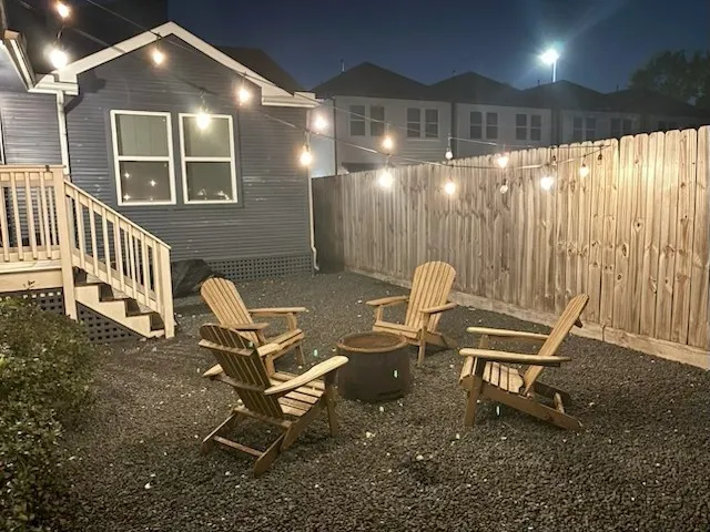 an outdoor view of a house with backyard and sitting area