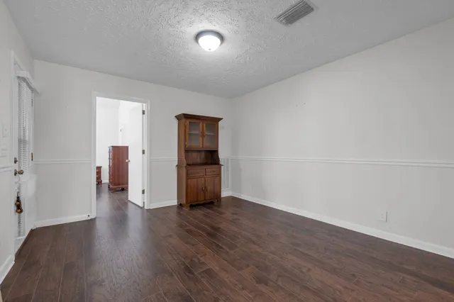 a view of a kitchen with furniture and wooden floor