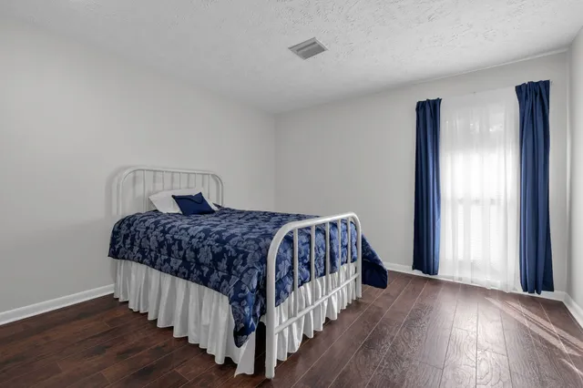 a bedroom with a bed and wooden floor