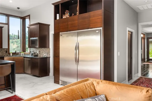 a view of a balcony with two chairs and a dining table next to a large window