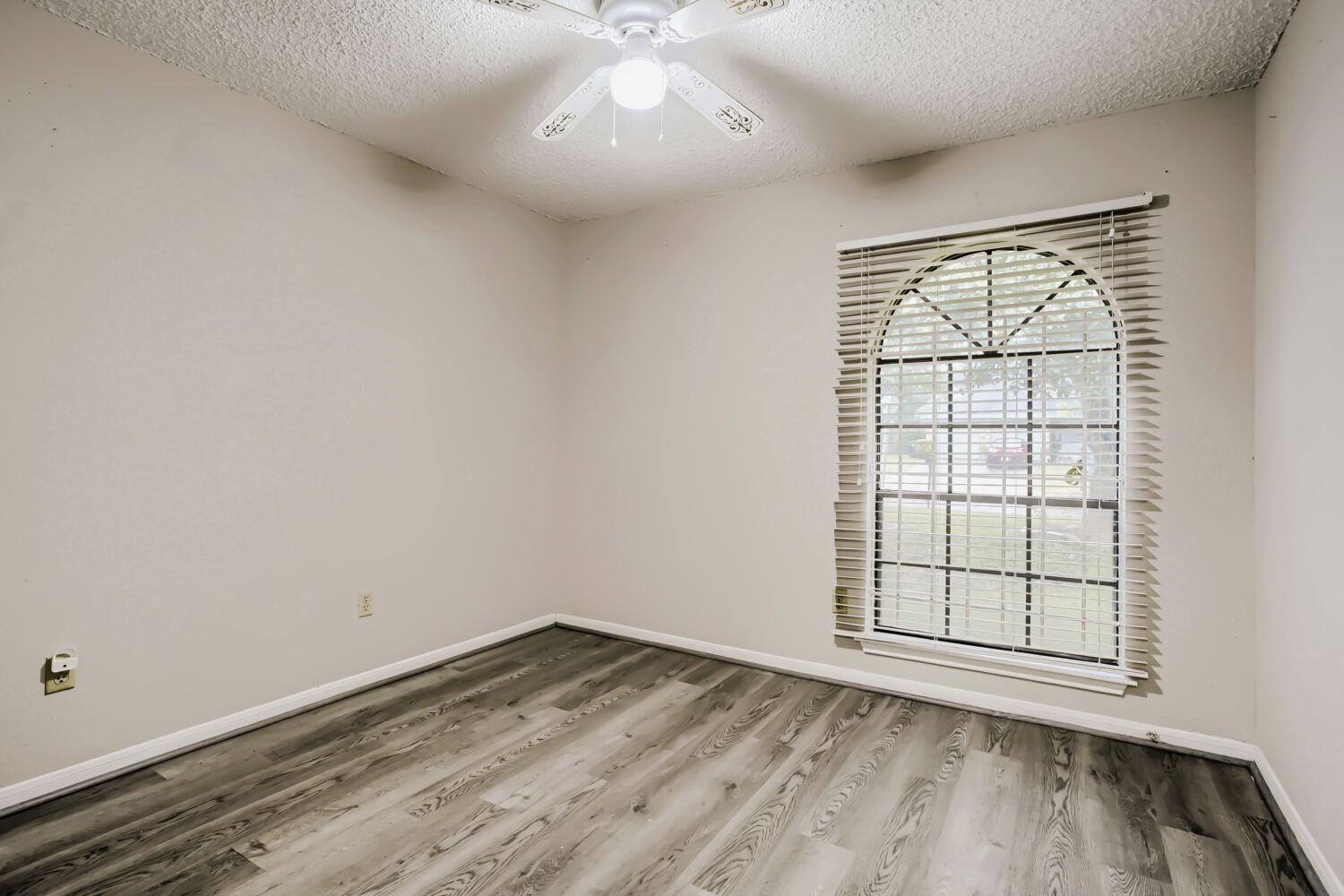 10103 Inwood Shadows Street Houston, TX 77088 - Photo 22 of 32 an empty room with wooden floor and windows