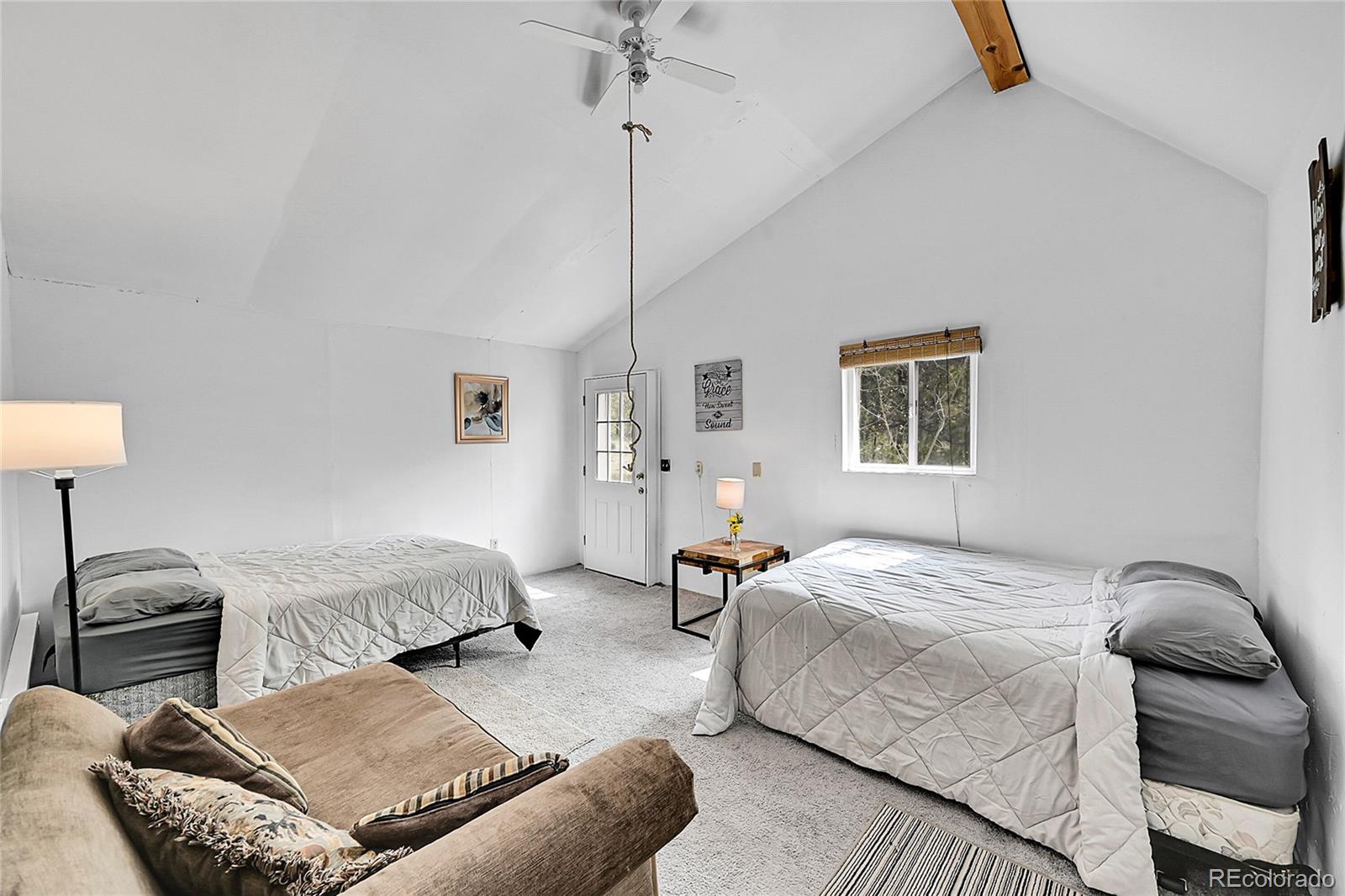 101 Campbell Road Bailey, CO 80421 - Photo 23 of 49 a bedroom with a bed a lamp and a couch