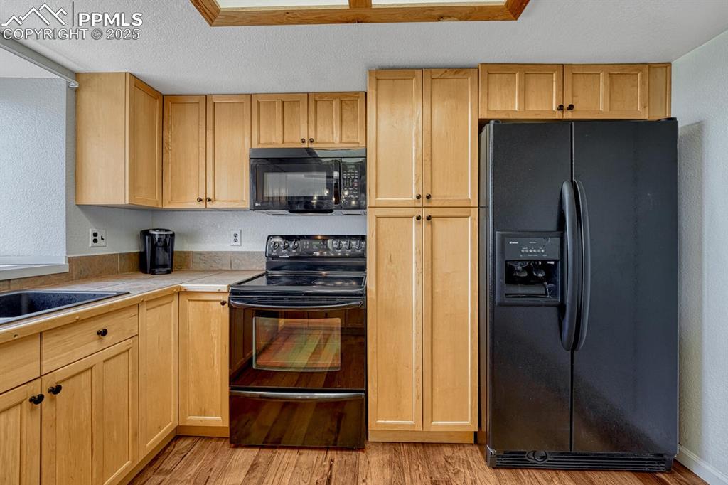 7550 Soap Weed Road Calhan, CO 80808 - Photo 15 of 50 a kitchen with a refrigerator sink and cabinets