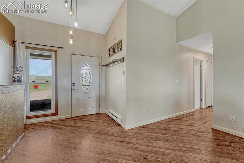 7550 Soap Weed Road Calhan, CO 80808 - Photo 4 of 50 a view of an empty room with wooden floor and a bathroom