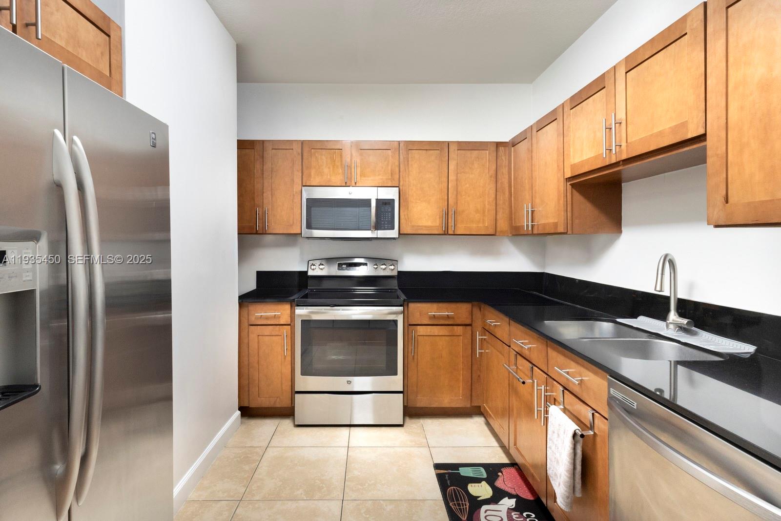 8395 Southwest 73rd Avenue, Unit 521 Miami, FL 33143 - Photo 11 of 21 a kitchen with stainless steel appliances granite countertop a sink stove and refrigerator
