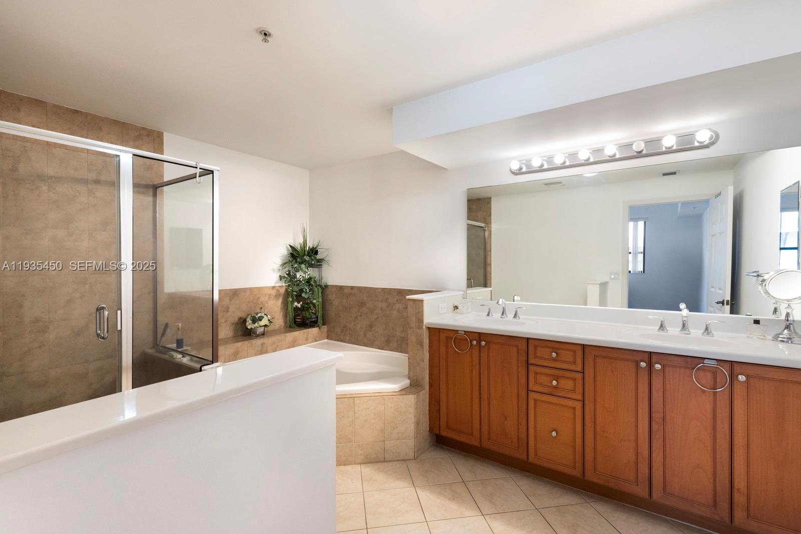 8395 Southwest 73rd Avenue, Unit 521 Miami, FL 33143 - Photo 14 of 21 a spacious bathroom with a tub sink and mirror
