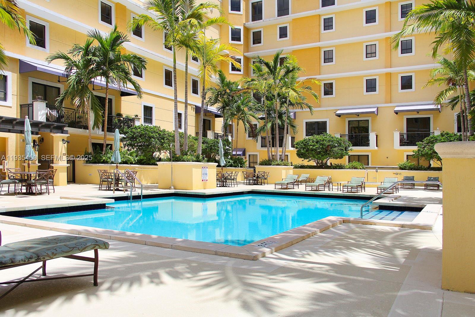 8395 Southwest 73rd Avenue, Unit 521 Miami, FL 33143 - Photo 20 of 21 a view of a swimming pool with a lounge chairs