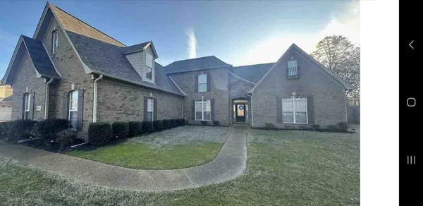a view of a big house with a small yard and plants