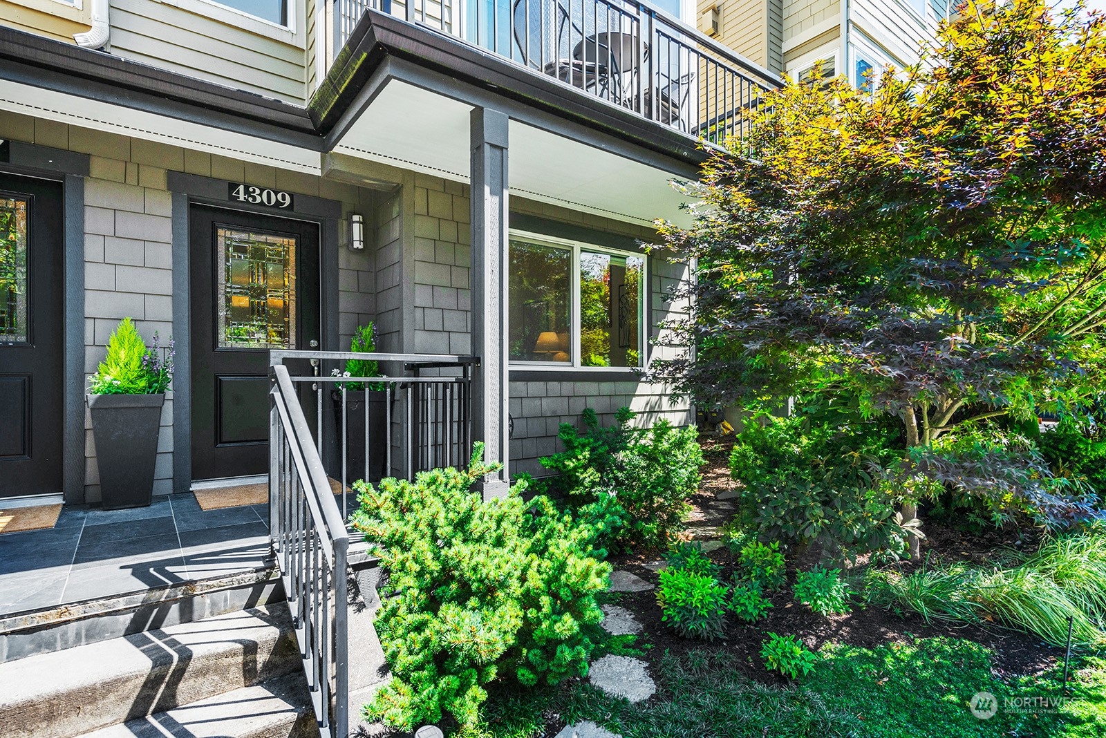 4309 Southwest Seattle Street Seattle, WA 98116 - Photo 2 of 36 a view of a house with potted plants and a tree