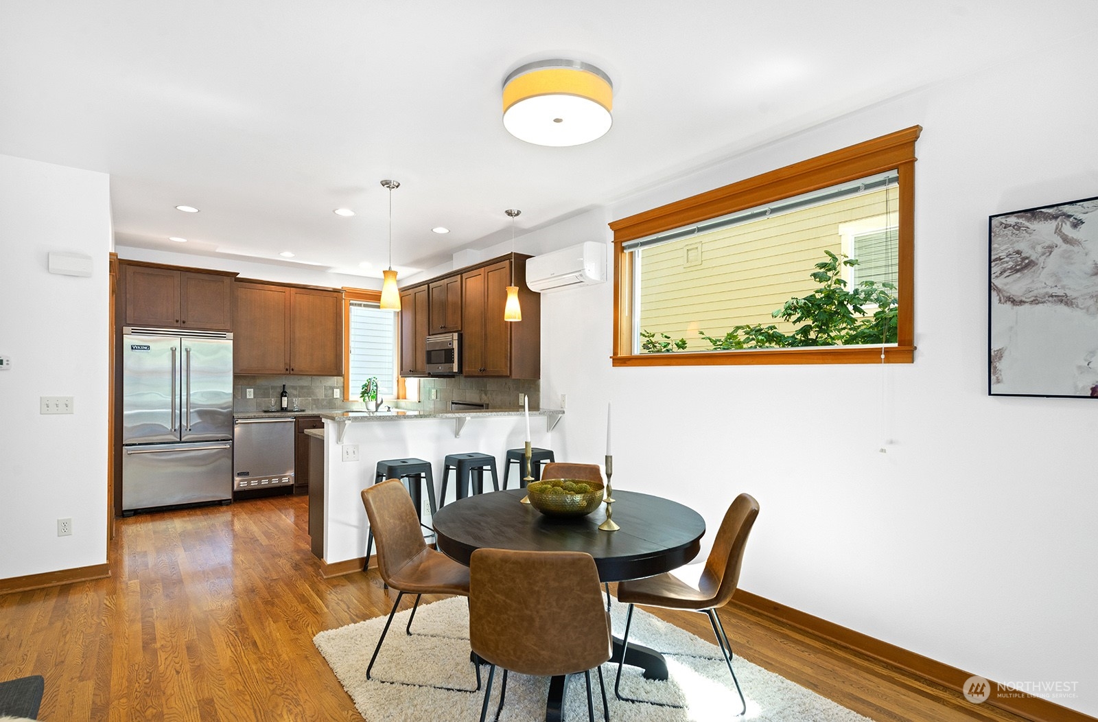 4309 Southwest Seattle Street Seattle, WA 98116 - Photo 10 of 36 a view of a dining room with furniture wooden floor and a kitchen