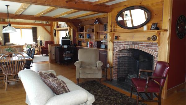 29 Potter Road Rowe, MA 01367 - Photo 8 of 30 a living room with furniture a fireplace a rug and a large window
