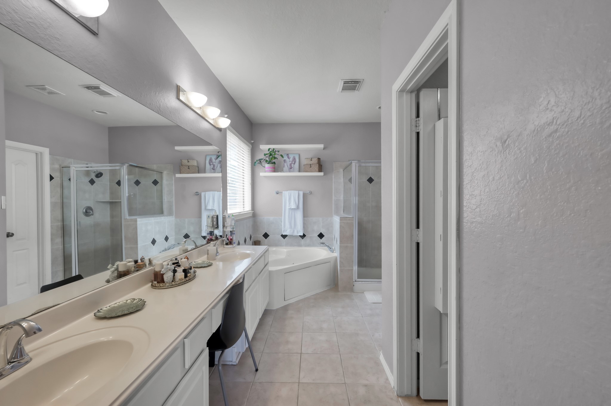 28522 Misty Cliff Lane Spring, TX 77386 - Photo 7 of 12 Large primary bathroom with dual vanities, soaking tub, separate shower, and abundant counter space. Bright and functional layout creates a spa-like retreat.
