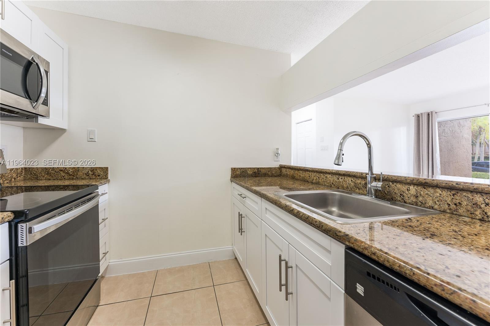 10521 Southwest 157th Place, Unit 102 Miami, FL 33196 - Photo 11 of 15 a close view of a sink and a stove top oven