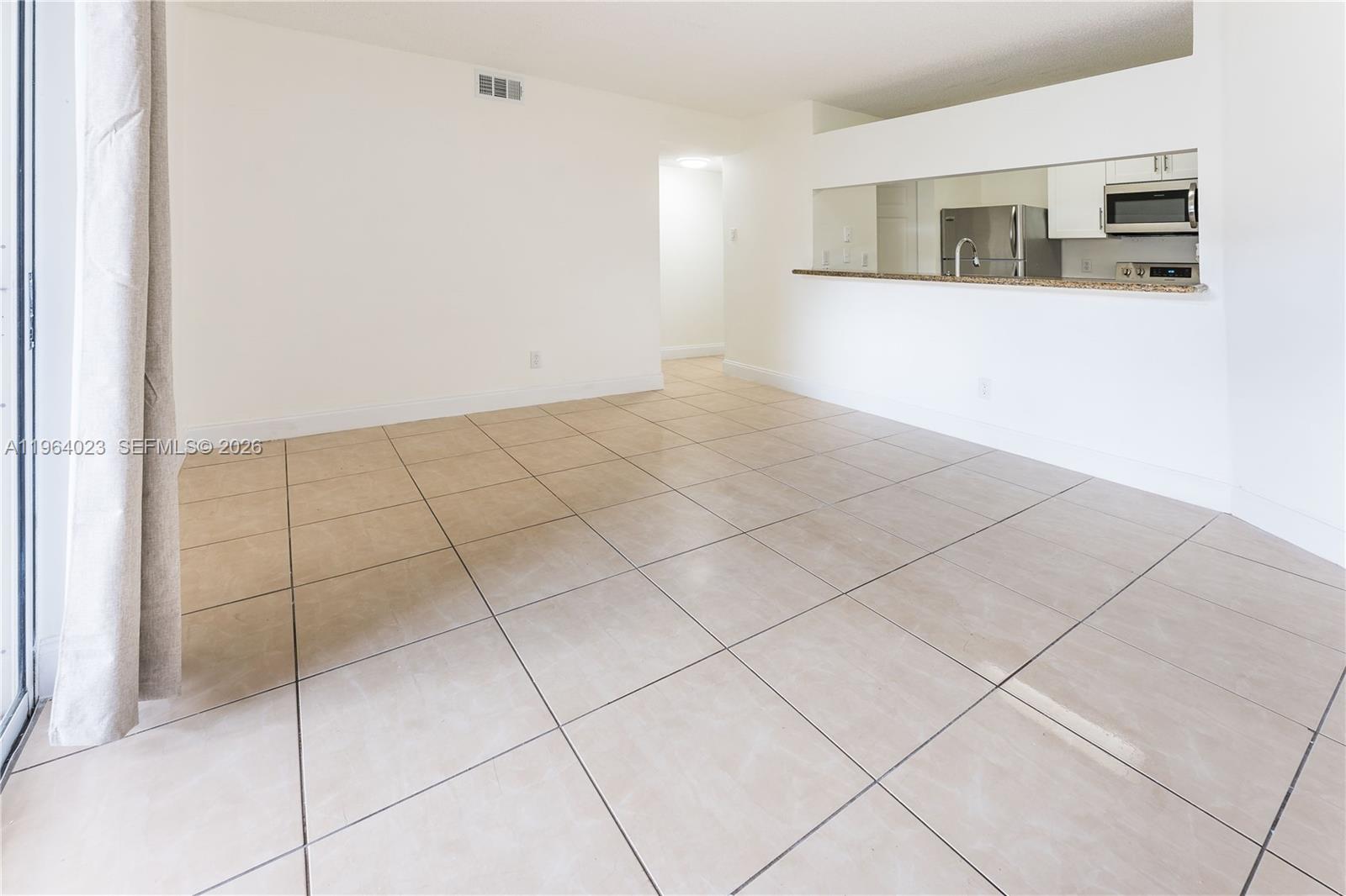 10521 Southwest 157th Place, Unit 102 Miami, FL 33196 - Photo 4 of 15 a view of an empty room and window