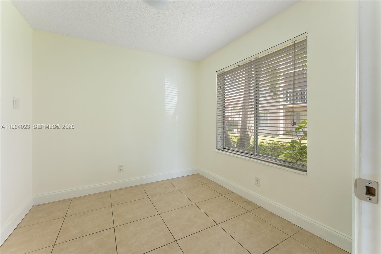 10521 Southwest 157th Place, Unit 102 Miami, FL 33196 - Photo 5 of 15 a view of an empty room with a window
