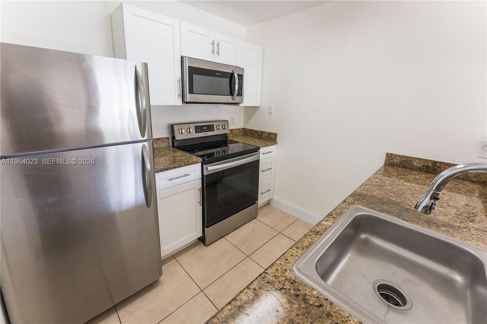 10521 Southwest 157th Place, Unit 102 Miami, FL 33196 - Photo 10 of 15 a kitchen with a refrigerator and a sink