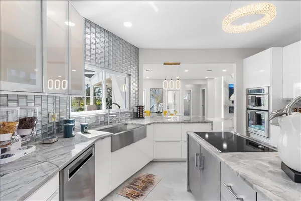 a kitchen with counter top space a sink appliances and cabinets
