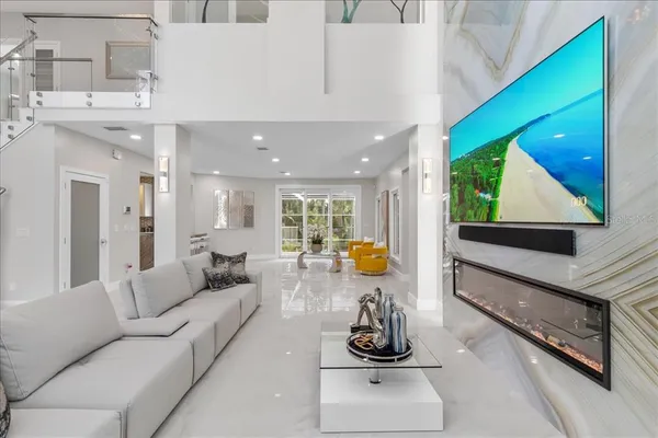 a large white kitchen with lots of counter space a sink and stainless steel appliances