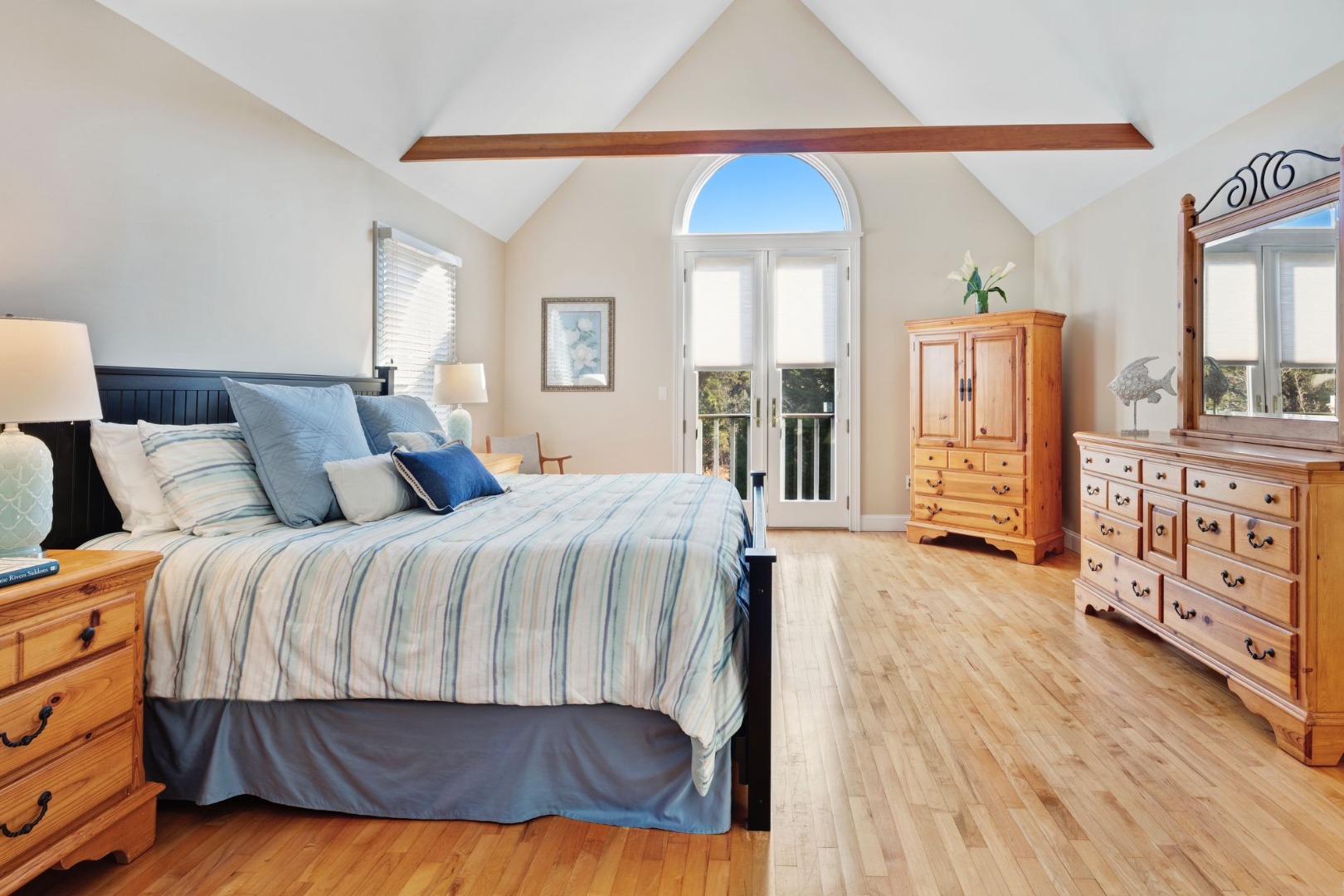 17 Thaxter Lane Edgartown, MA 02539 - Photo 12 of 23 a bedroom with a large bed a chandelier and dresser