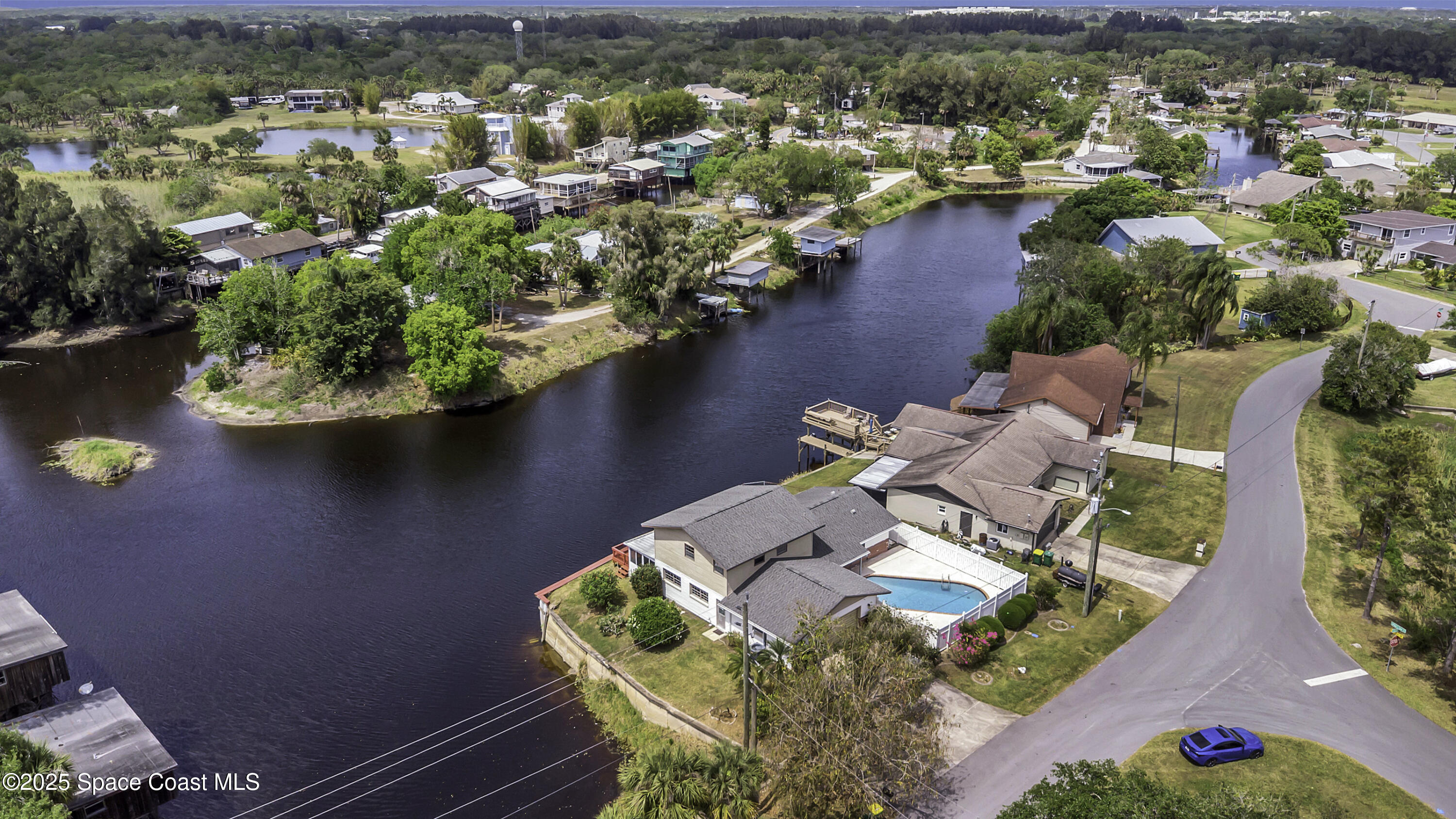 an aerial view of residential houses with outdoor space and lake view