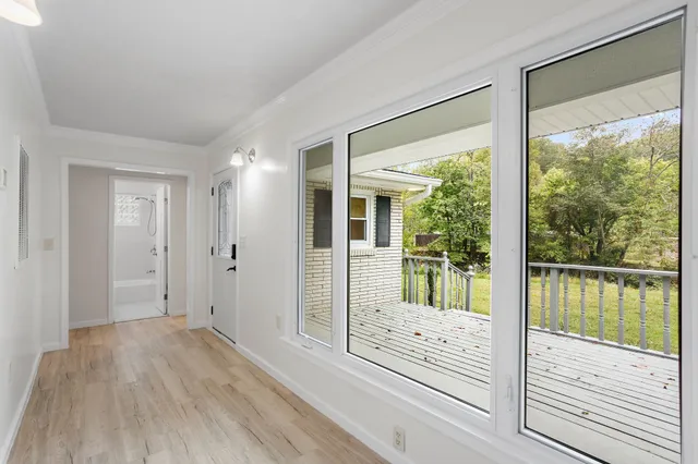 a view of a hallway with wooden floor and floor to ceiling window