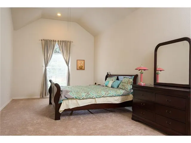 a bedroom with a bed window and dresser