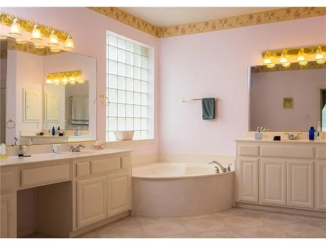 a bathroom with a tub a sink and mirror