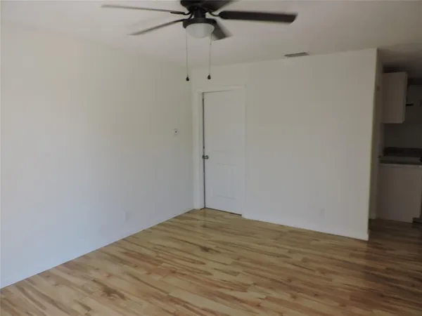 a view of a room with wooden floor and a ceiling fan