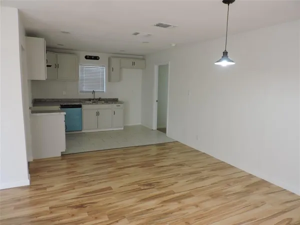 a kitchen with stainless steel appliances granite countertop a sink cabinets and wooden floor