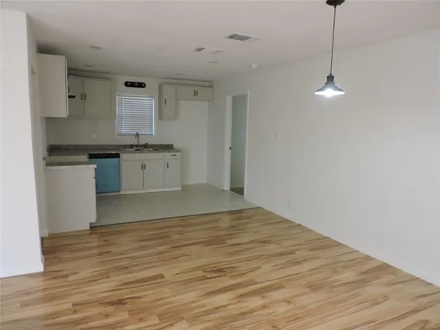a kitchen with stainless steel appliances granite countertop a sink cabinets and wooden floor