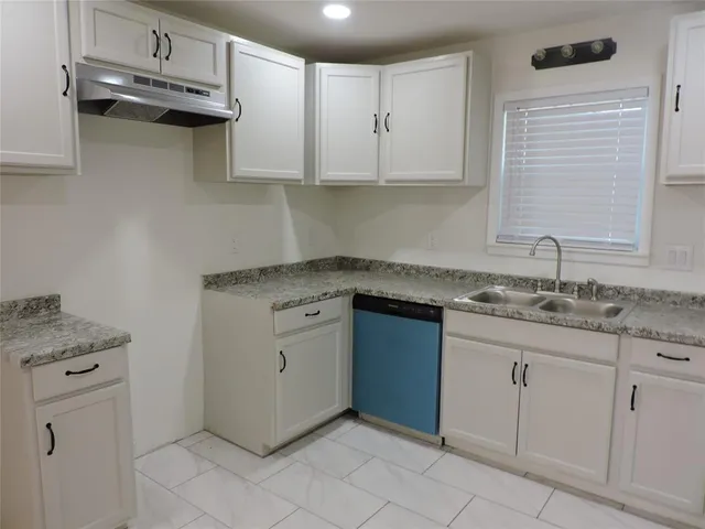 a kitchen with granite countertop white cabinets and white appliances