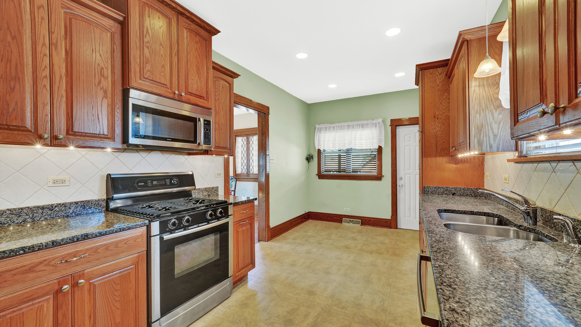 3130 Clinton Avenue Berwyn, IL 60402 - Photo 11 of 30 a kitchen with stainless steel appliances granite countertop a stove a sink and a microwave