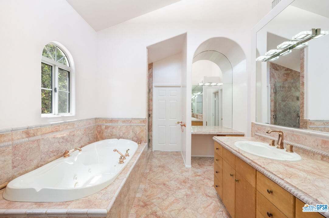 3290 Malcolm Avenue Los Angeles, CA 90034 - Photo 39 of 58 a bathroom with a granite countertop tub a sink and a large mirror
