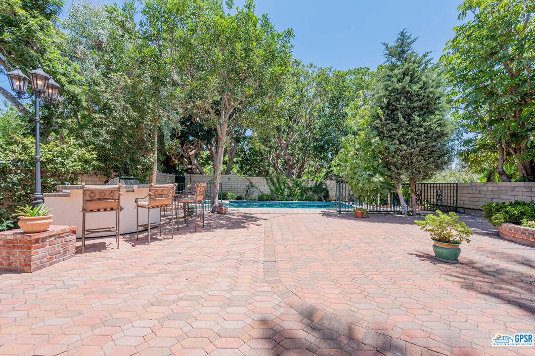 3290 Malcolm Avenue Los Angeles, CA 90034 - Photo 52 of 58 a bench is sitting in middle of a yard with potted plants and large trees