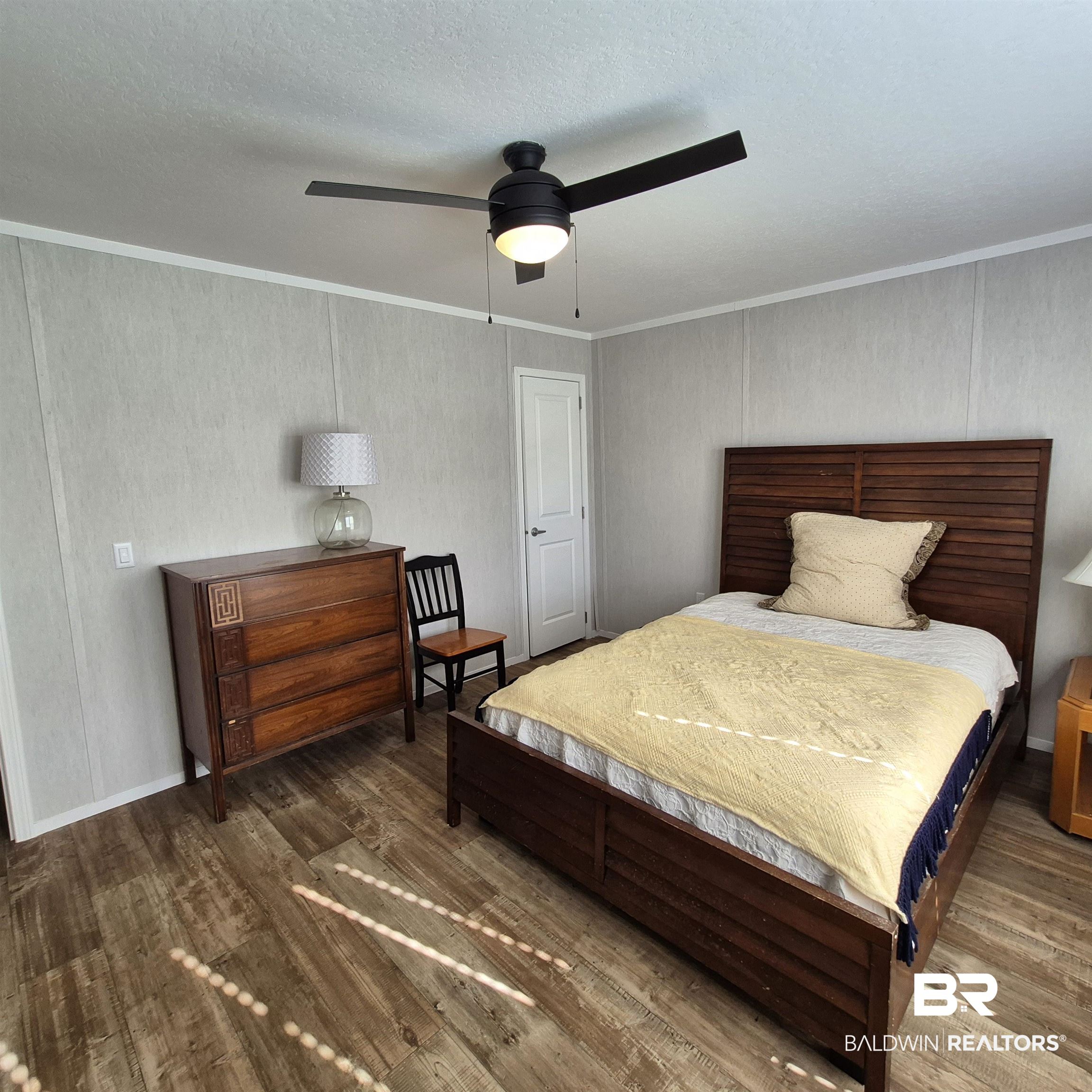8867 Old Stage Road Repton, AL 36475 - Photo 24 of 37 Bedroom featuring ceiling fan, wood finished floors, ornamental molding, and a textured ceiling