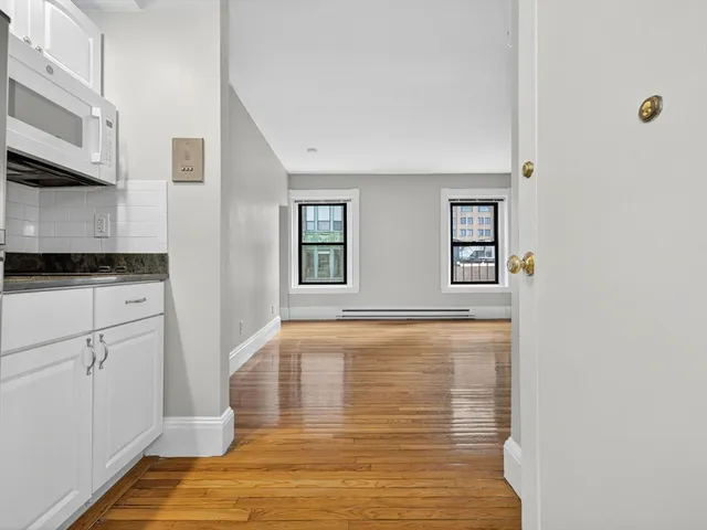 a view of a kitchen with wooden floor and cabinets