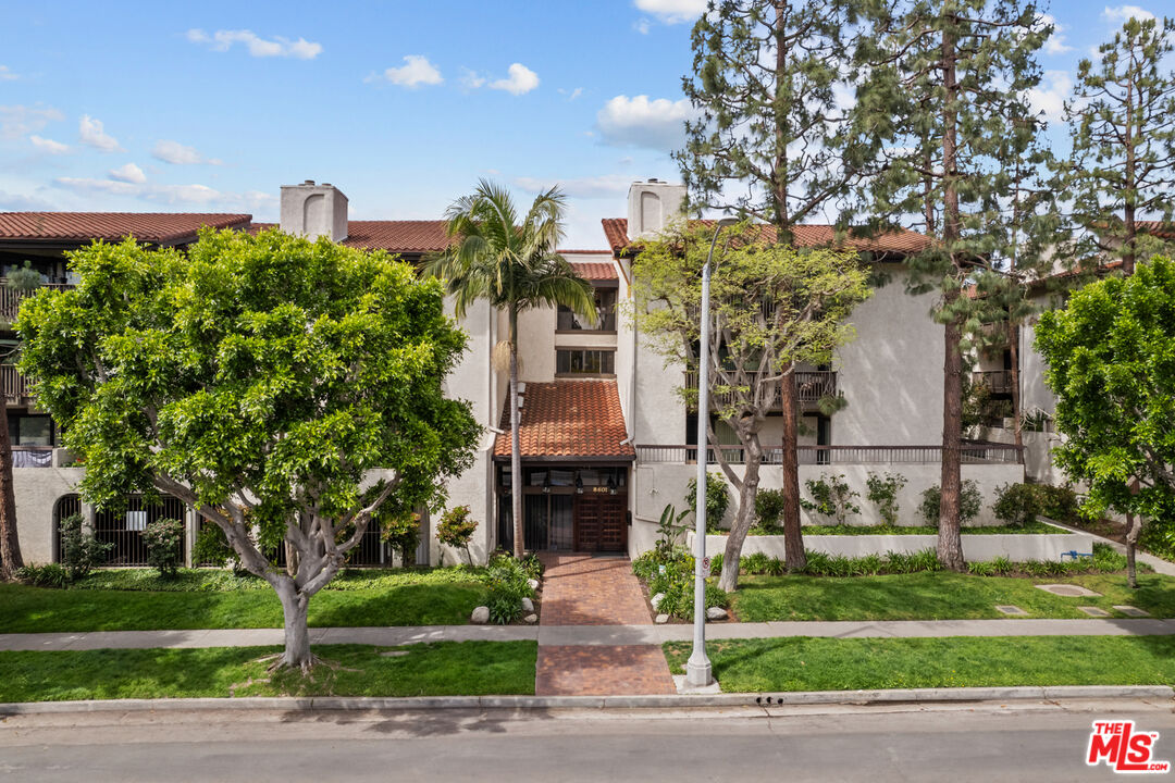 a front view of a house with garden and plants