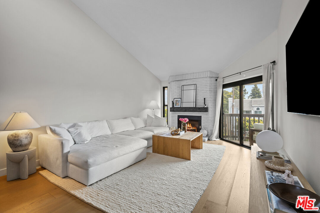 8601 Falmouth Avenue, Unit 404 Playa del Rey, CA 90293 - Photo 3 of 28 a living room with furniture a fireplace and a flat screen tv