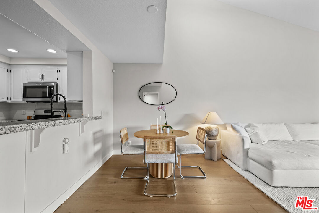 8601 Falmouth Avenue, Unit 404 Playa del Rey, CA 90293 - Photo 5 of 28 a living room with furniture a flat screen tv and kitchen view