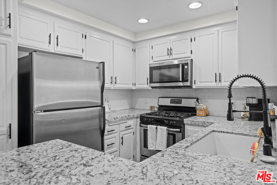 8601 Falmouth Avenue, Unit 404 Playa del Rey, CA 90293 - Photo 7 of 28 a kitchen with stainless steel appliances granite countertop a refrigerator stove top oven and sink