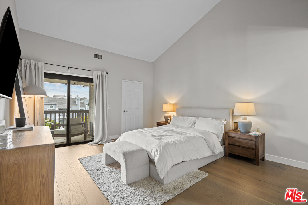 8601 Falmouth Avenue, Unit 404 Playa del Rey, CA 90293 - Photo 10 of 28 a spacious bedroom with a bed a couch and a large window