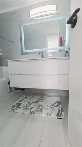 a bathroom with a sink a mirror and shower