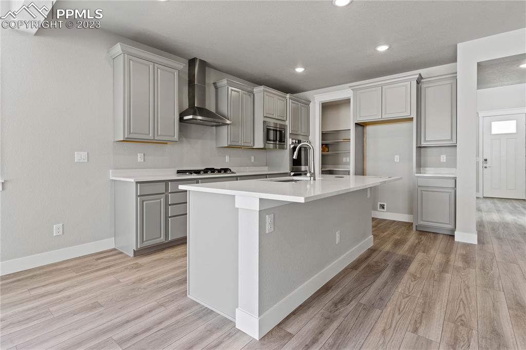 2154 Coyote Mint Drive Monument, CO 80132 - Photo 11 of 46 a kitchen with kitchen island a sink a stove a refrigerator and white cabinets