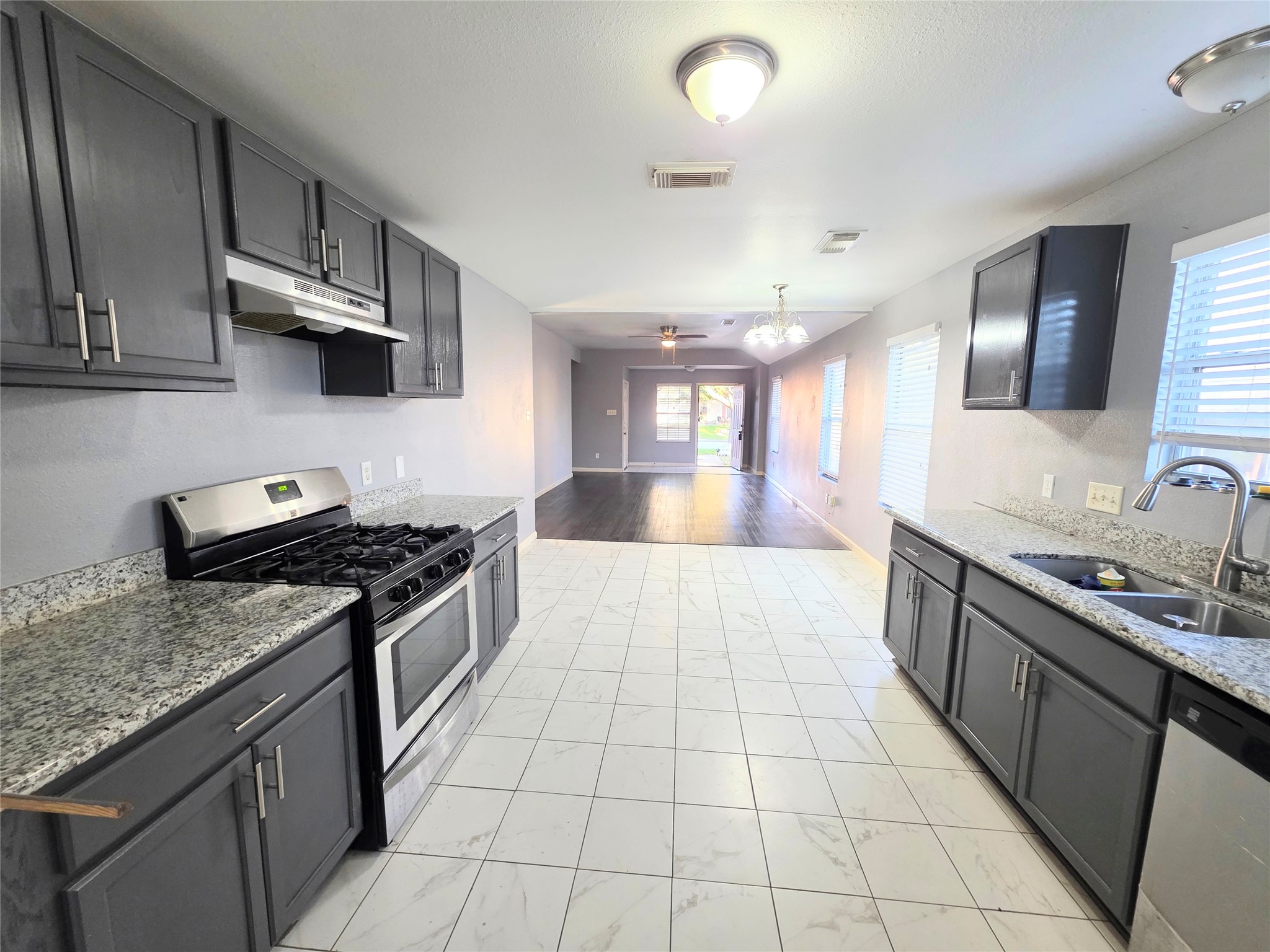 9514 Manorstone Court Houston, TX 77044 - Photo 2 of 9 a large kitchen with stainless steel appliances granite countertop a stove a sink and a microwave