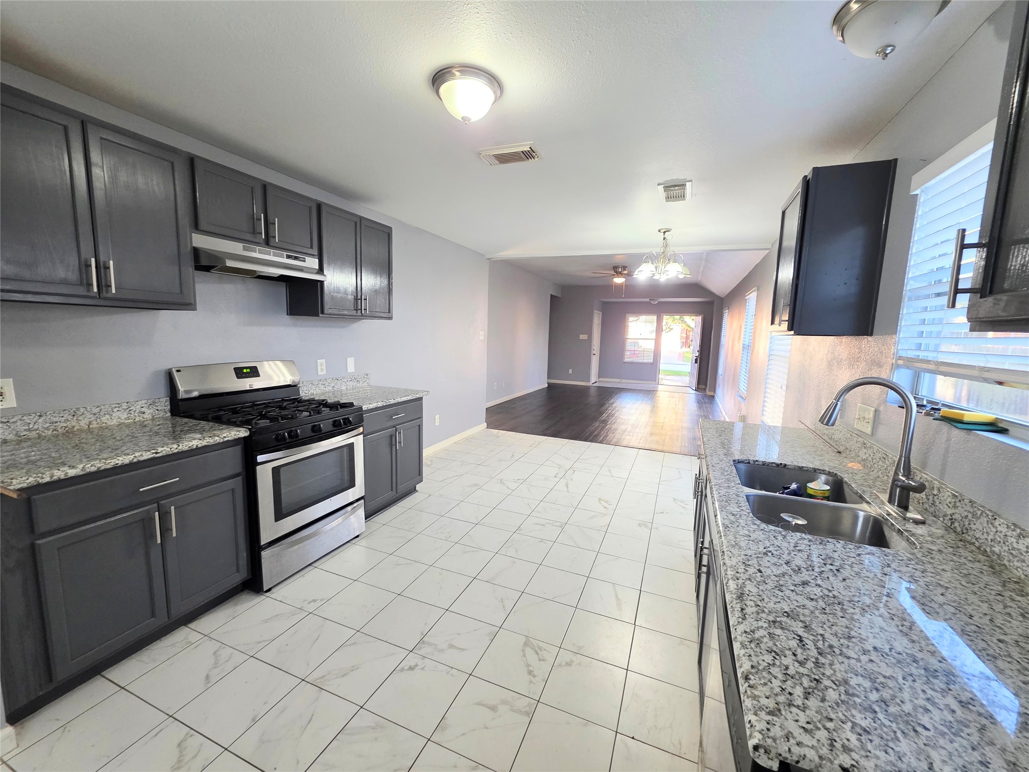 9514 Manorstone Court Houston, TX 77044 - Photo 4 of 9 a kitchen with stainless steel appliances granite countertop a stove a sink and a microwave