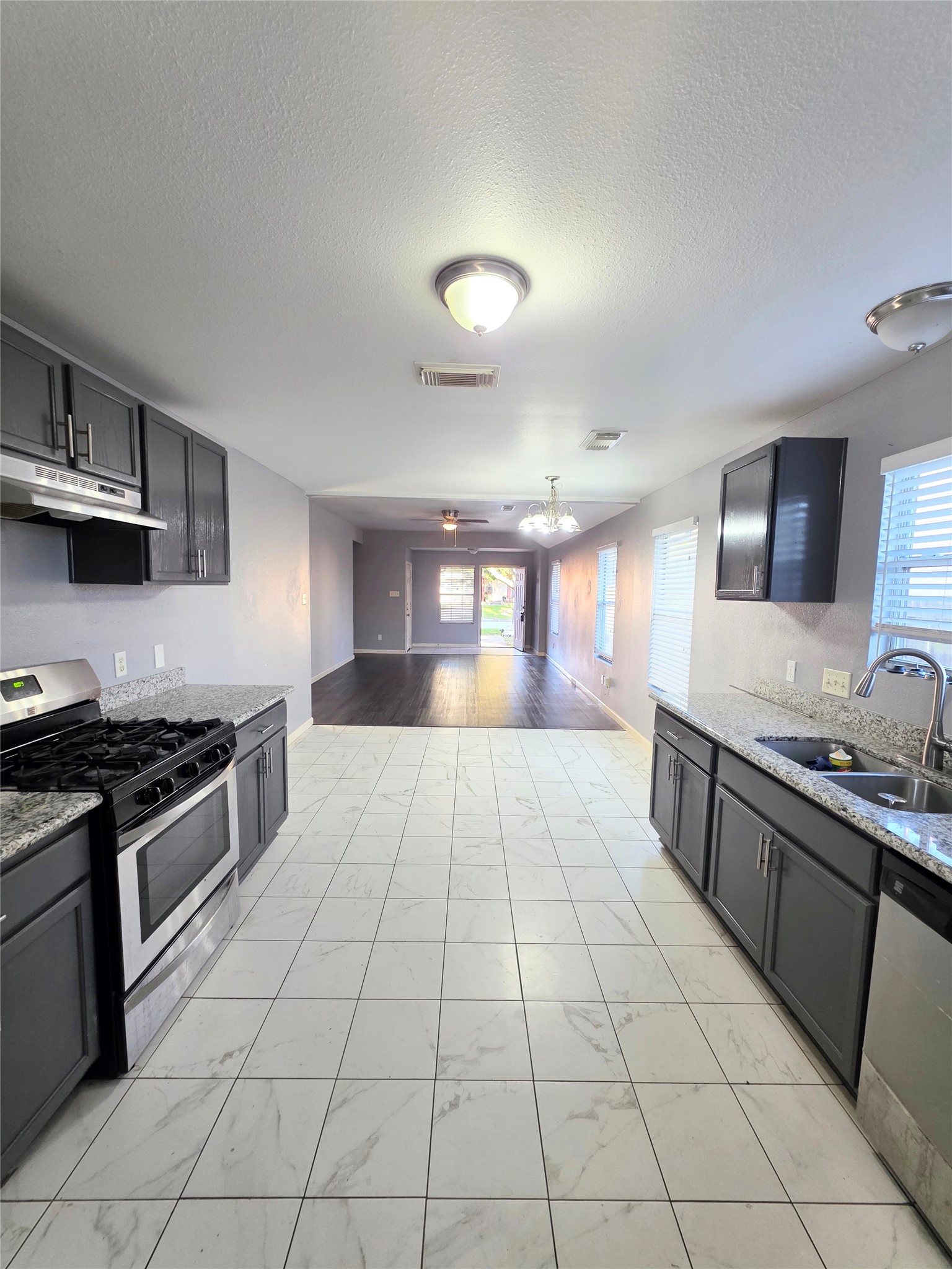 9514 Manorstone Court Houston, TX 77044 - Photo 5 of 9 a large kitchen with stainless steel appliances granite countertop a stove and a sink