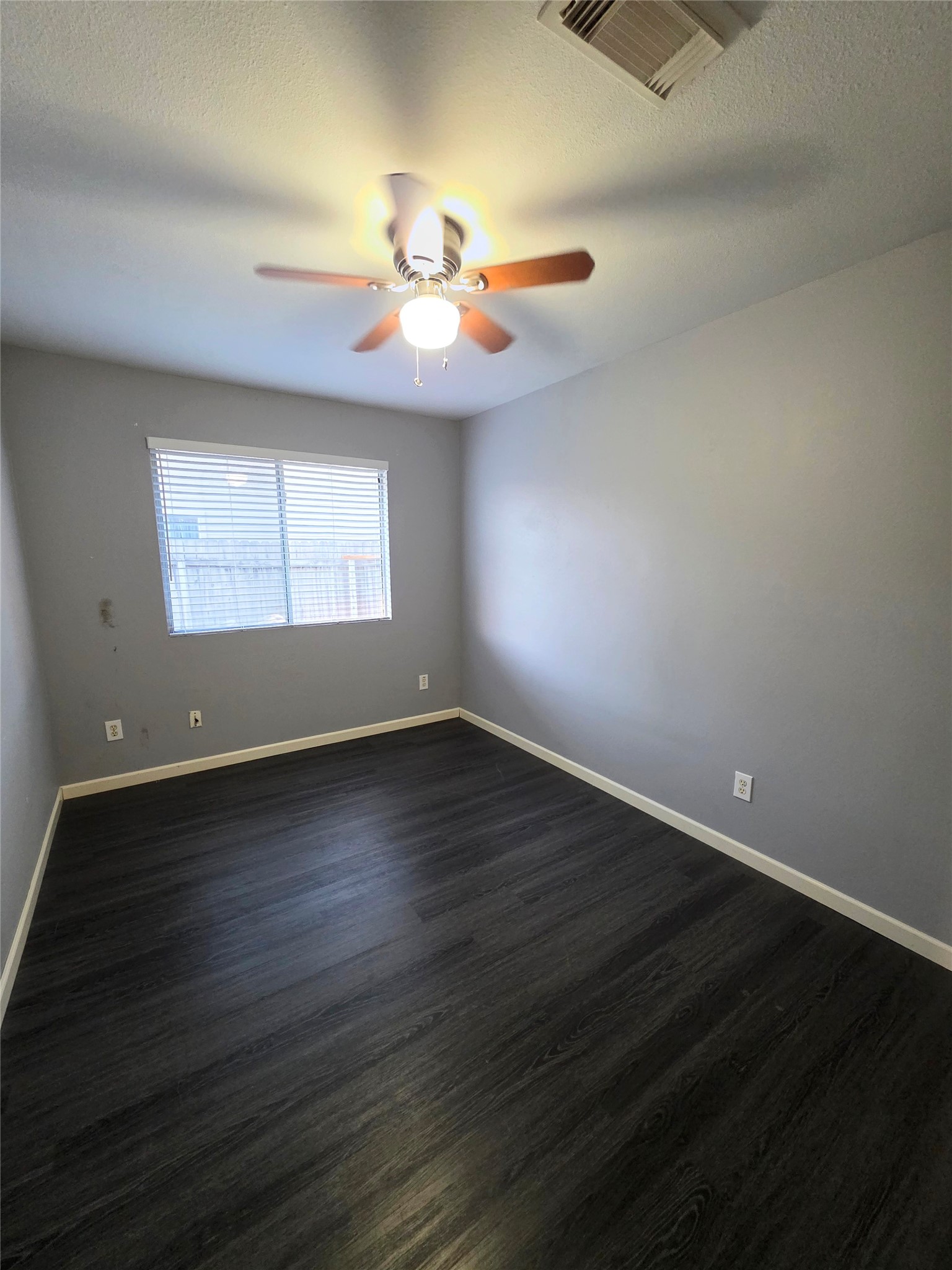 9514 Manorstone Court Houston, TX 77044 - Photo 8 of 9 an empty room with wooden floor chandelier fan and windows