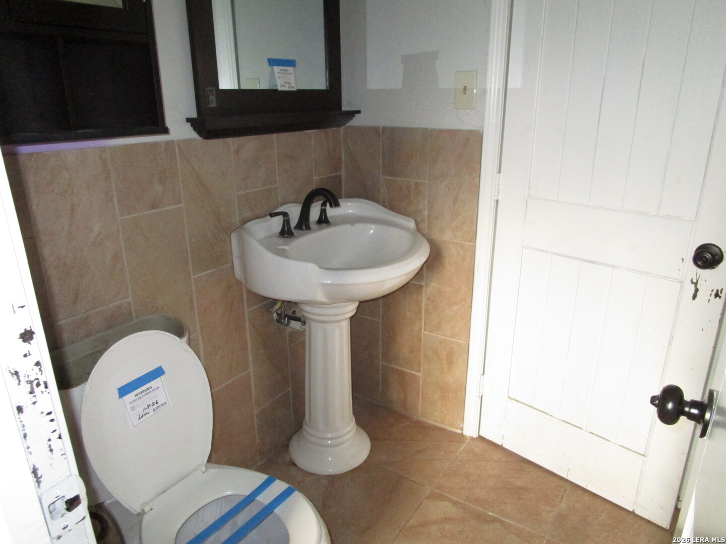 7106 Timber Ridge Drive San Antonio, TX 78227 - Photo 4 of 13 a bathroom with a sink a toilet and mirror