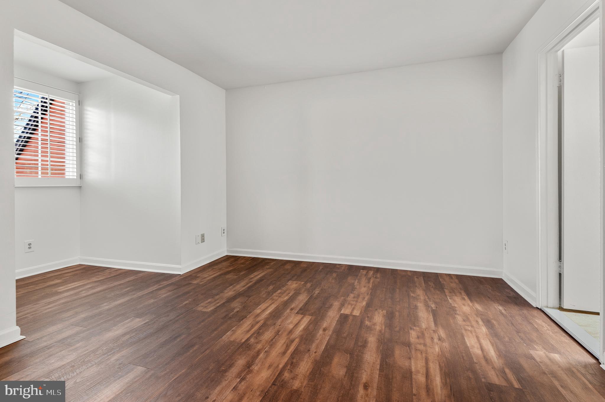 4942 Columbia Road, Unit 5 37 Columbia, MD 21044 - Photo 25 of 36 a view of an empty room with wooden floor and a window