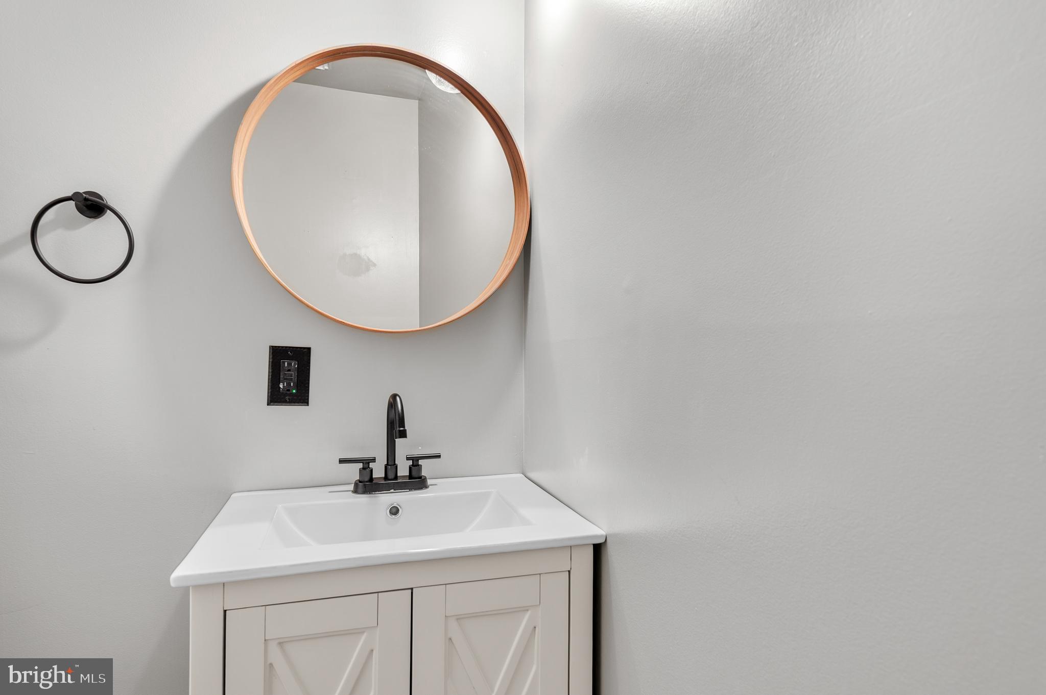 4942 Columbia Road, Unit 5 37 Columbia, MD 21044 - Photo 8 of 36 a bathroom with a sink and a mirror